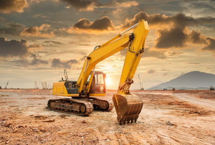 A hydraulic excavator-loader machine at an earth-moving site.