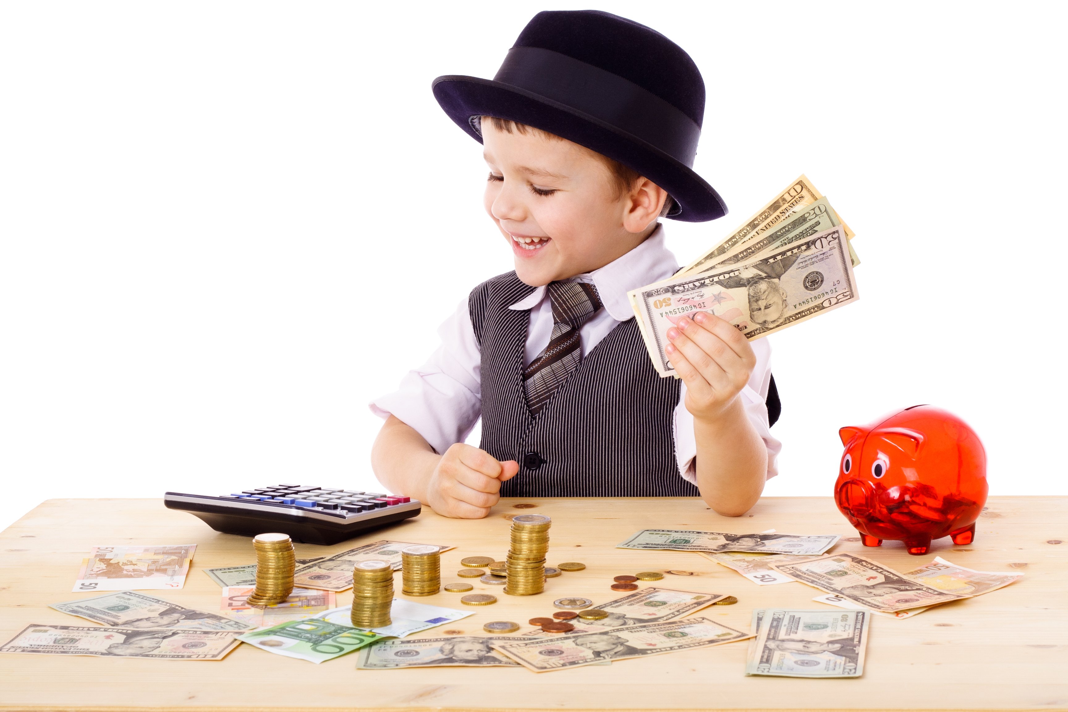 A kid in a tie and hat holds a wad of cash and looks at money on the table. 