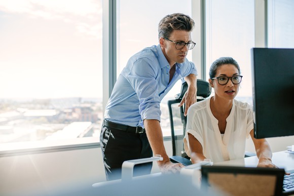 Corporate colleagues looking at a computer screen together.