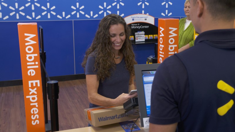 A Walmart customer scans an item at the Mobile Express counter