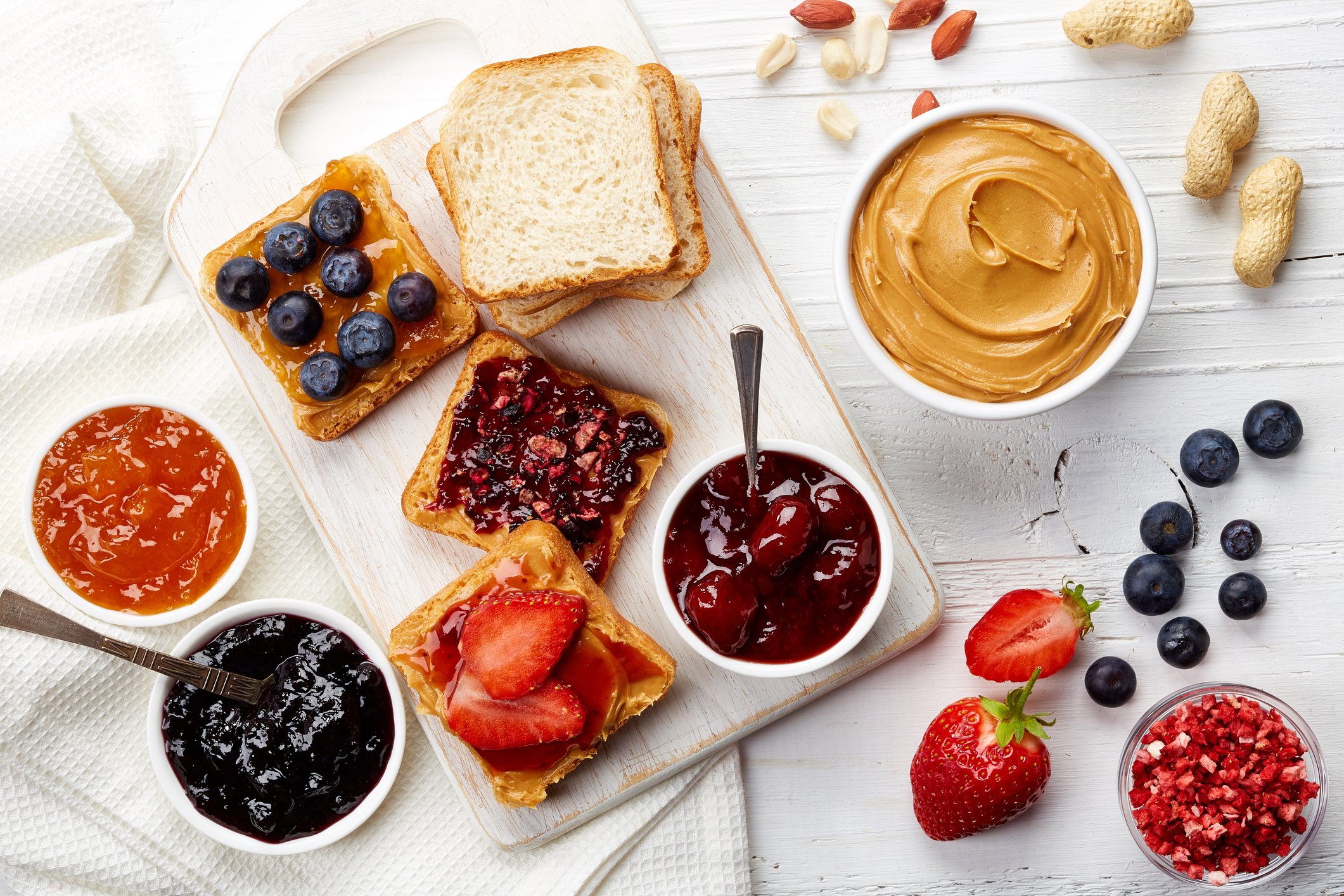 Peanut butter, jams, and jellies spread on a table