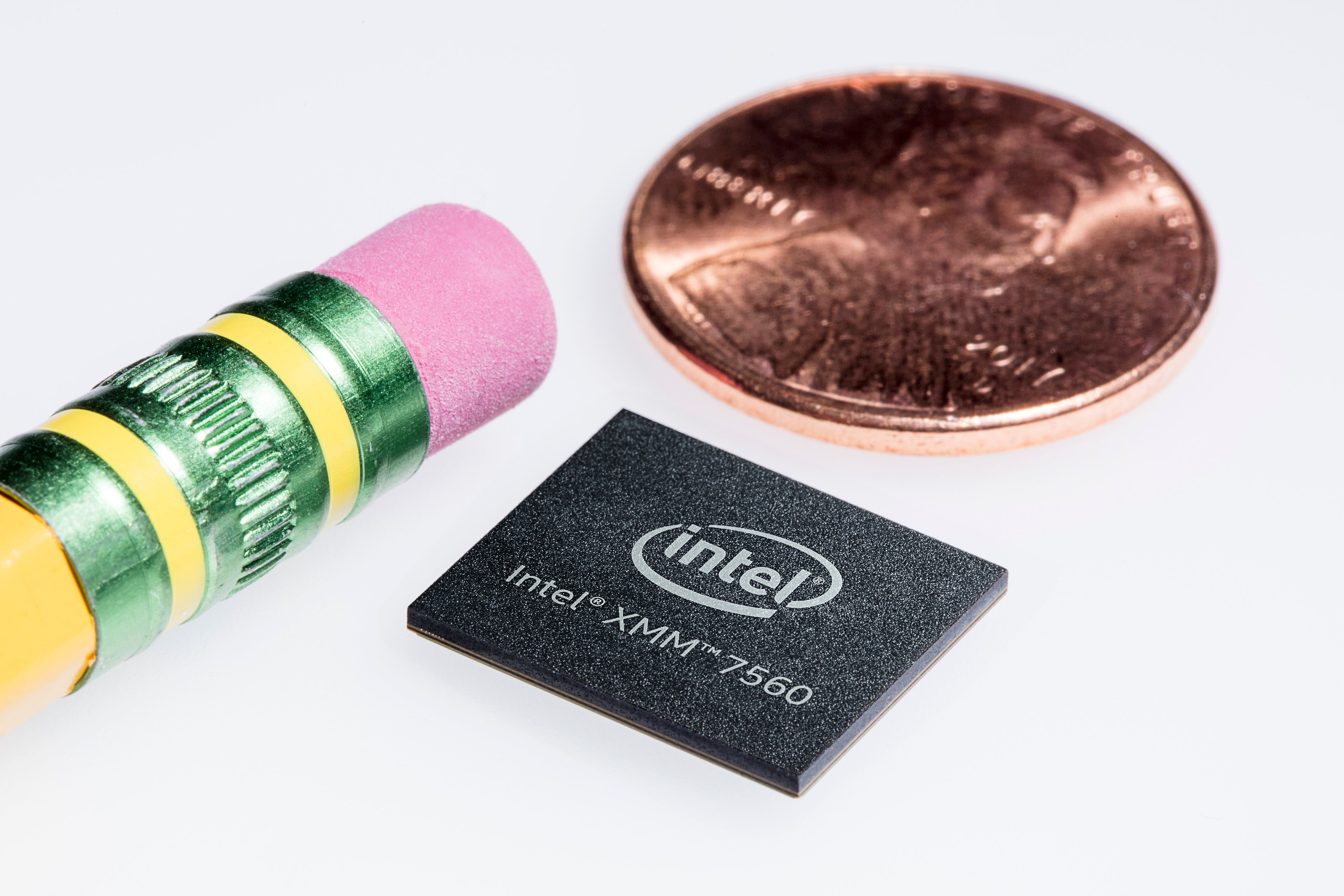 To the left is a pencil eraser, and then to the right of it are a penny (top) and an Intel modem chip (bottom).