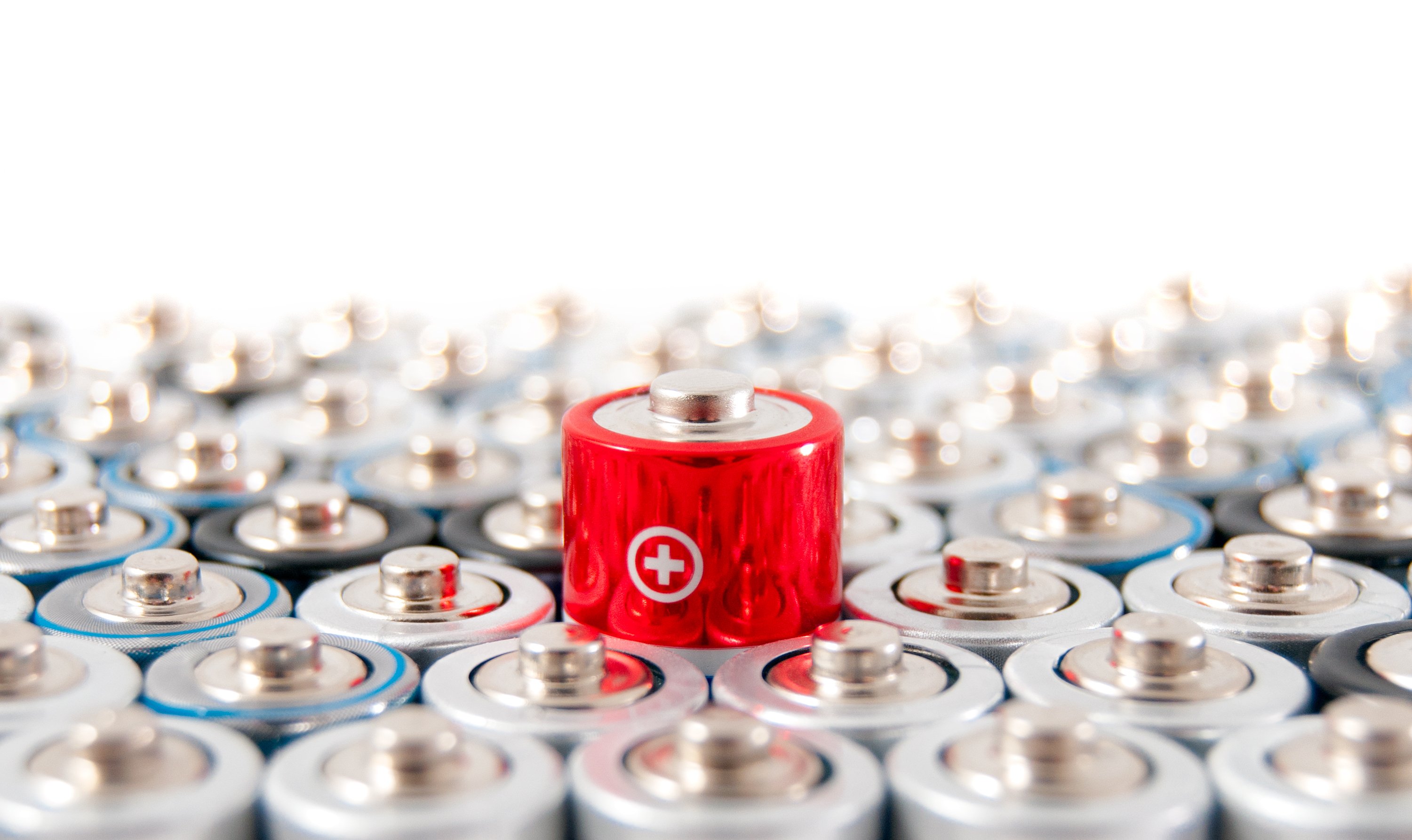Rows of AA batteries with one red battery showing above the rest