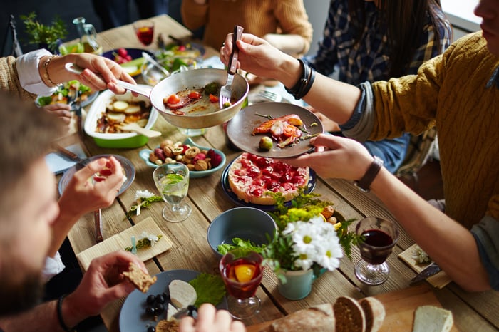 A family eating dinner at the dining room table. 