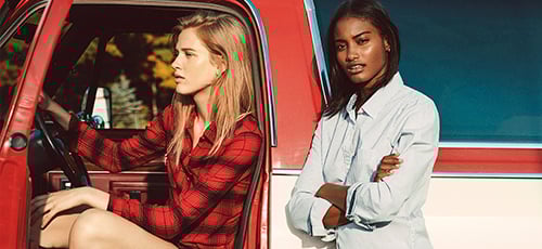 A pair of Abercrombie models pose inside and beside a pickup truck.
