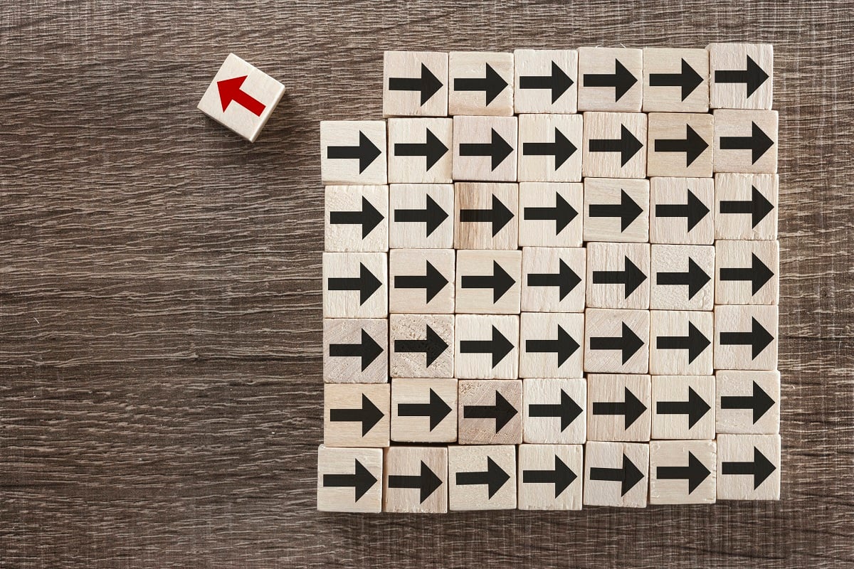 A square of blocks with arrows on them. All the arrows except one are black and point to the right. One is red and points to the left. 