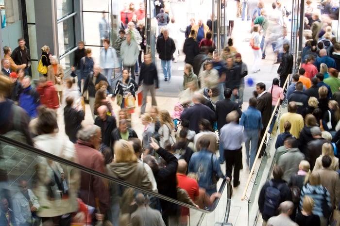 Shoppers packed on a crowded escalator in a busy store. 