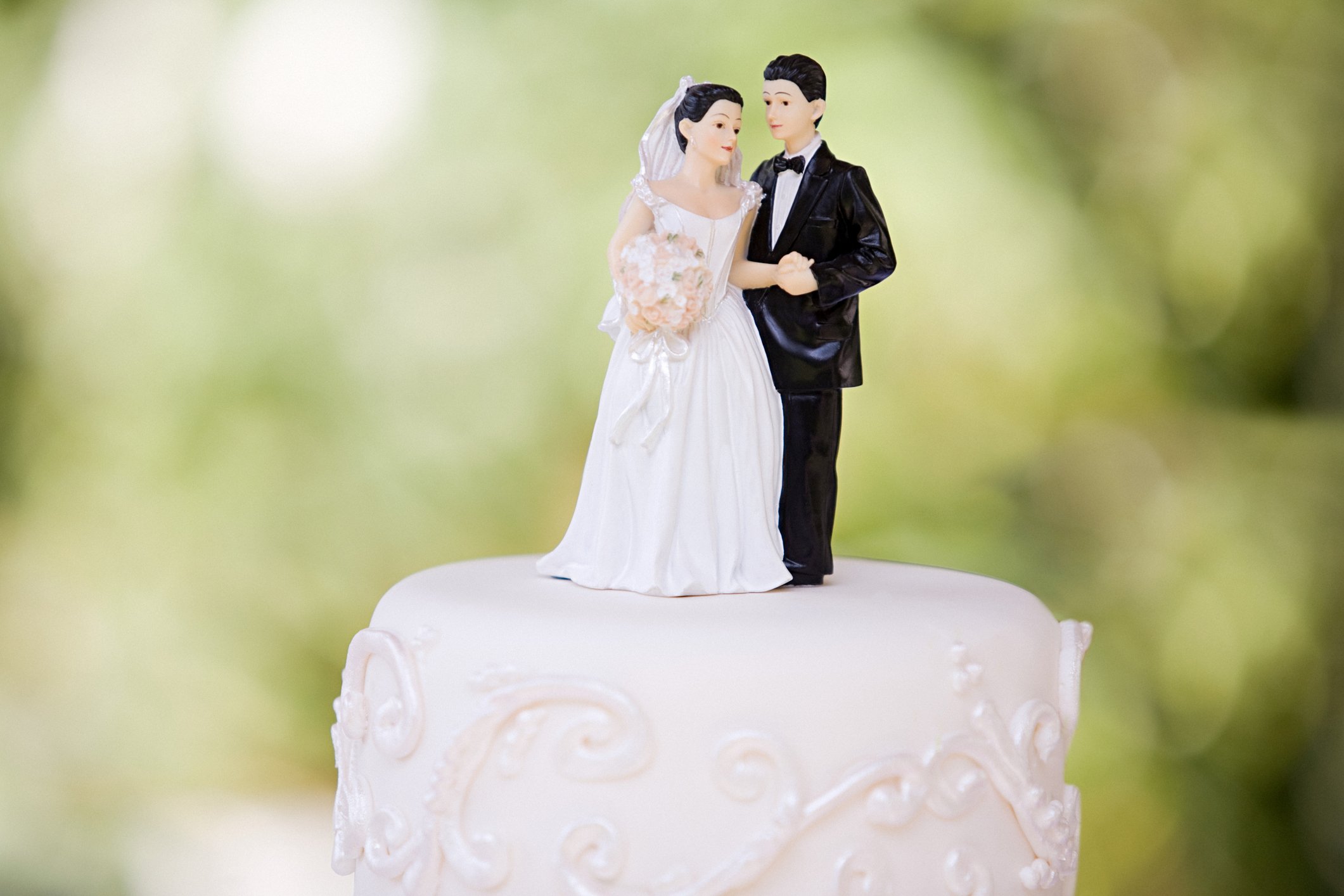 Bride and groom figurines on top of a wedding cake.
