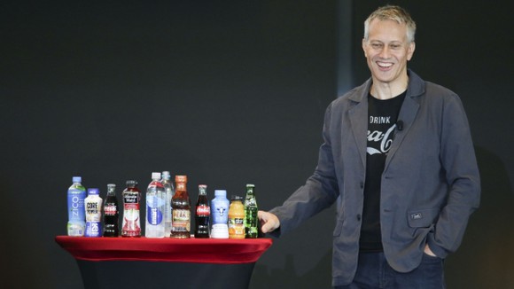 Coca-Cola CEO James Quincey standing beside an array of Coca-Cola products at the company's 2017 investor conference.