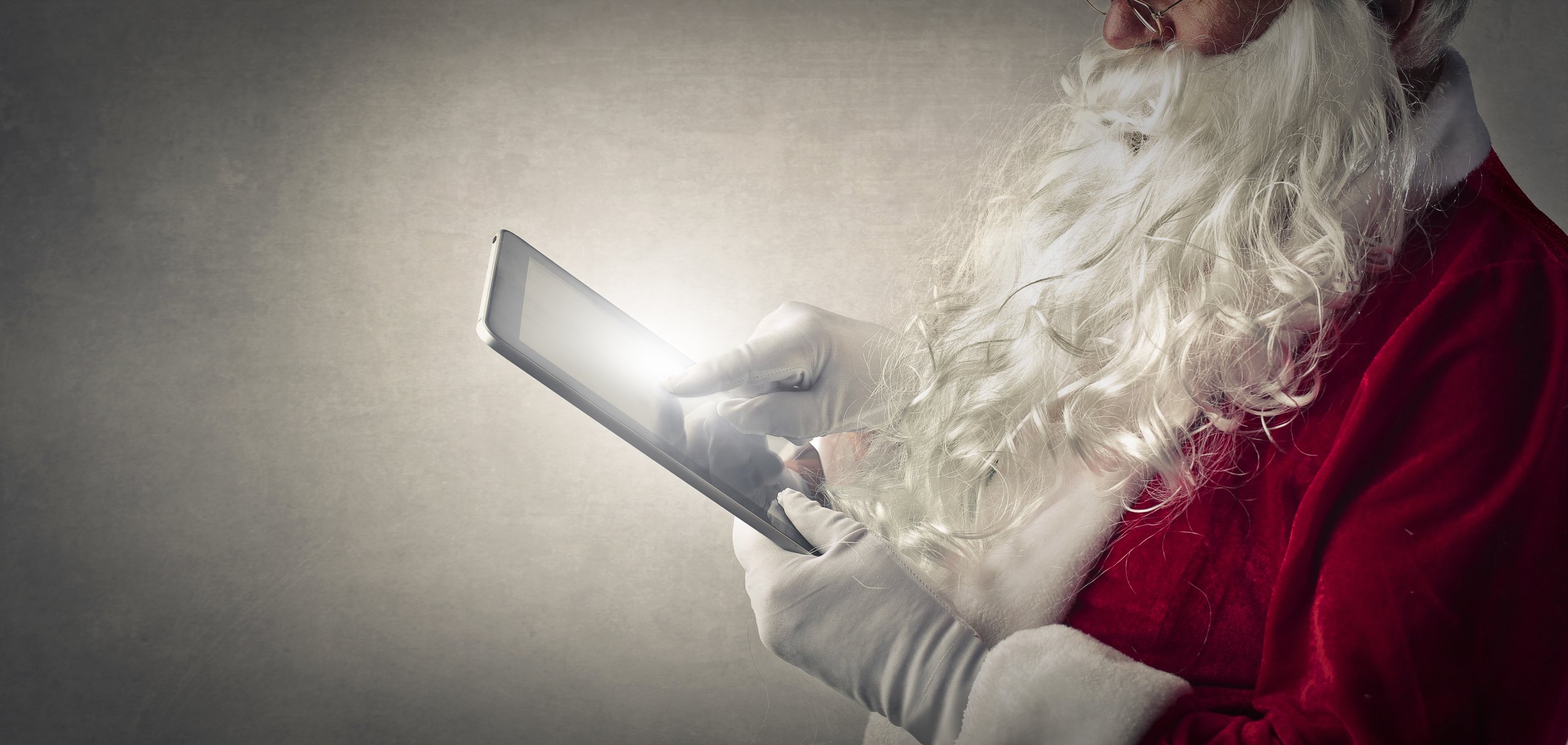 Santa Claus using a tablet.