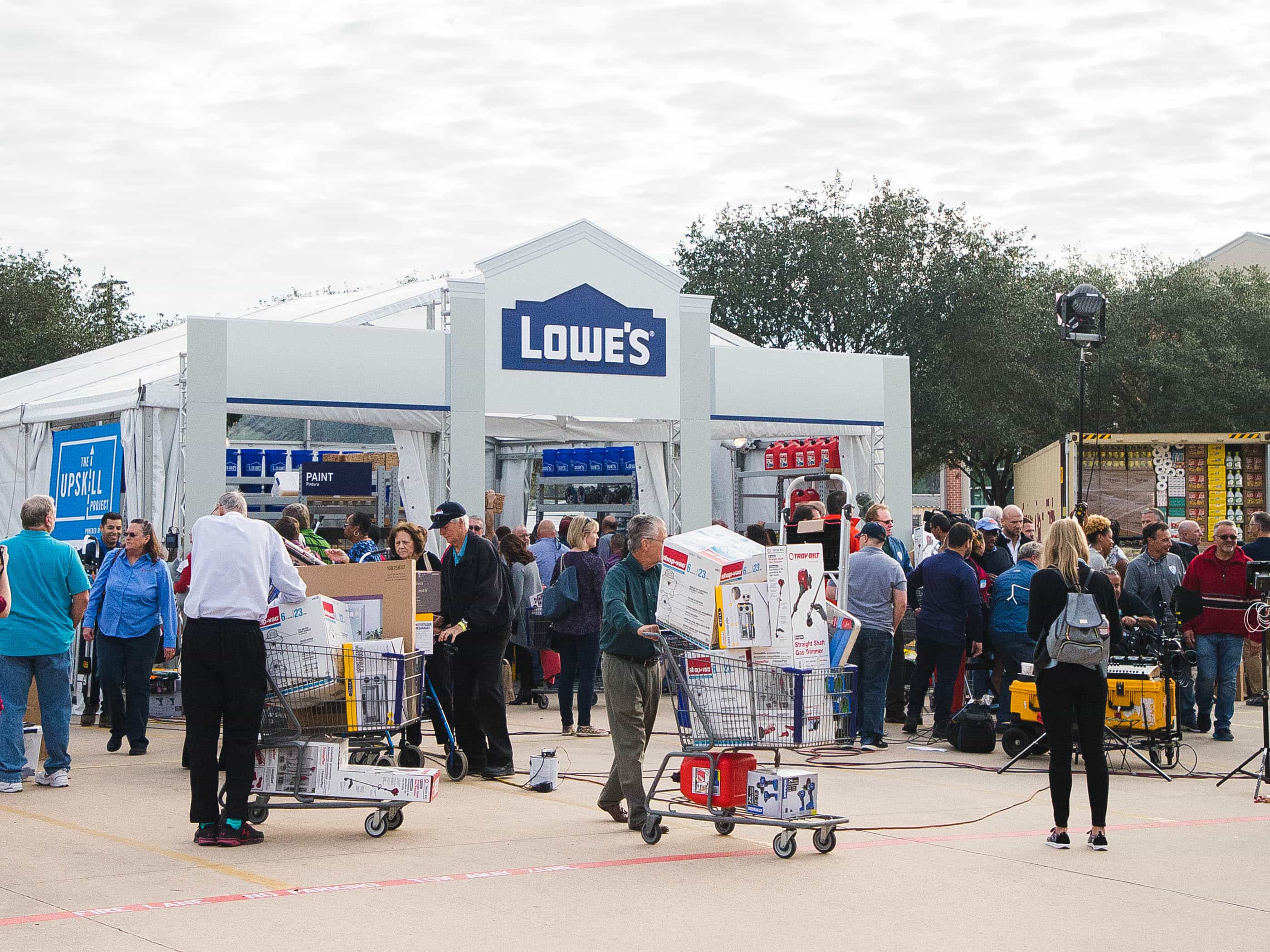 A crowd of people gather outside a Lowe's tent after Hurricane Harvey to pick up supplies and home goods.