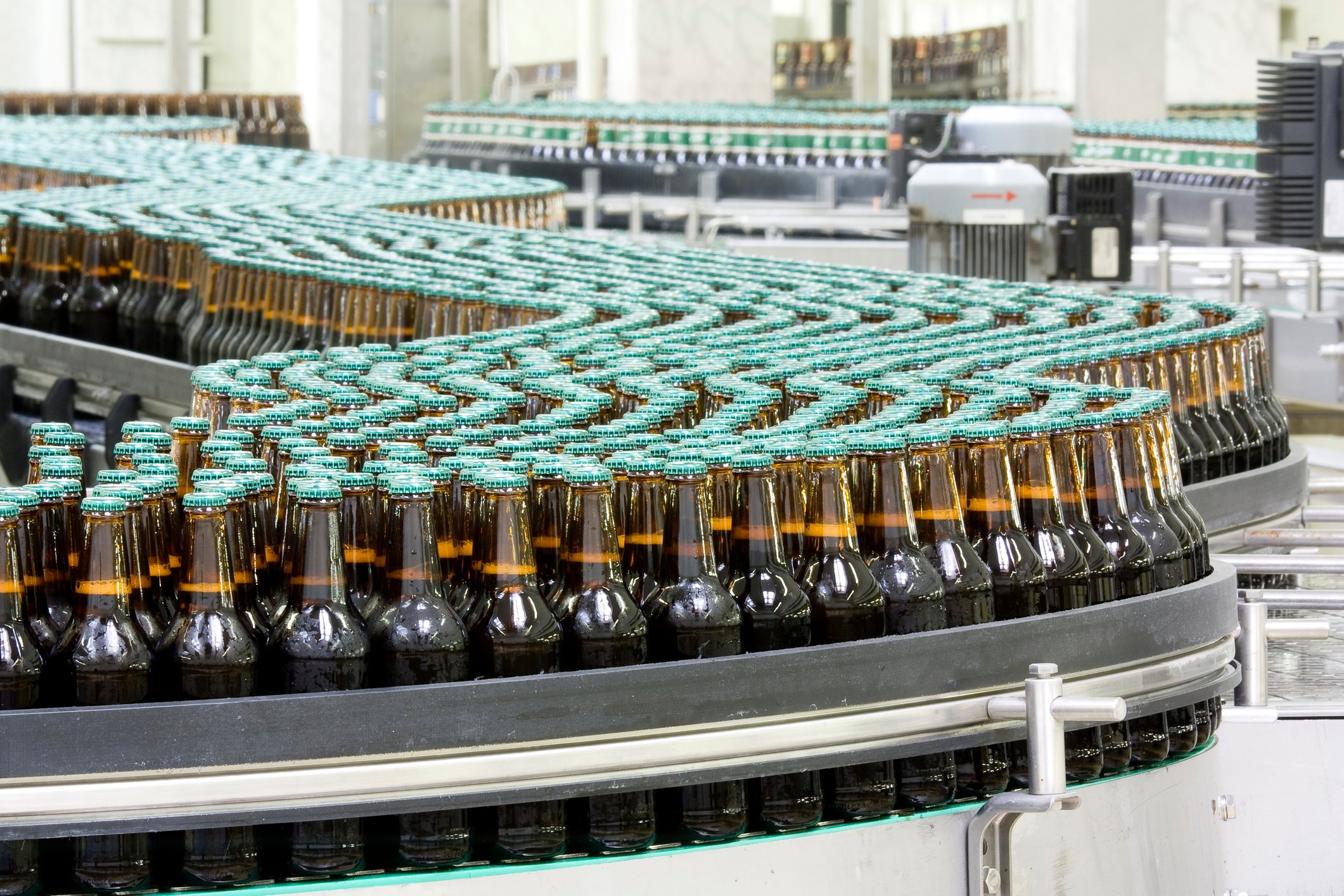 un-branded bottles on a conveyor belt in a bottling plant.