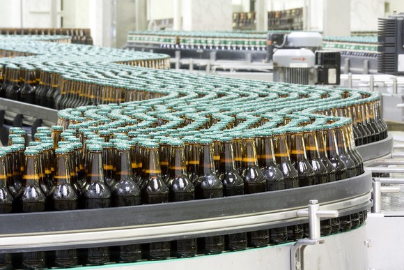 un-branded bottles on a conveyor belt in a bottling plant.
