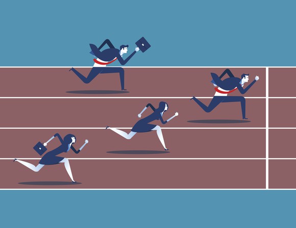 Graphic image of two businessmen and two businesswomen running on a race track, with one businessman about to cross finish line. 