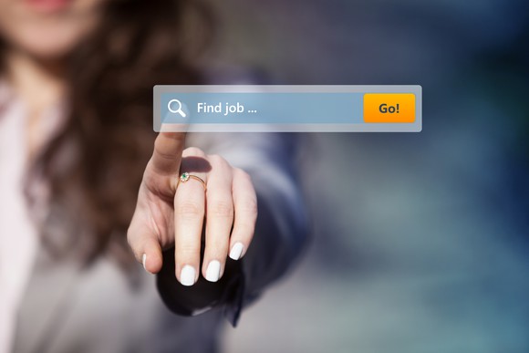 A woman touches a screen with a search box reading find a job.