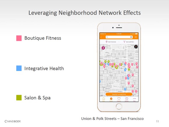 An Apple iPhone with a screen of a map with numerous boutique fitness, integrative health, and salon & spa locations clustered close together.