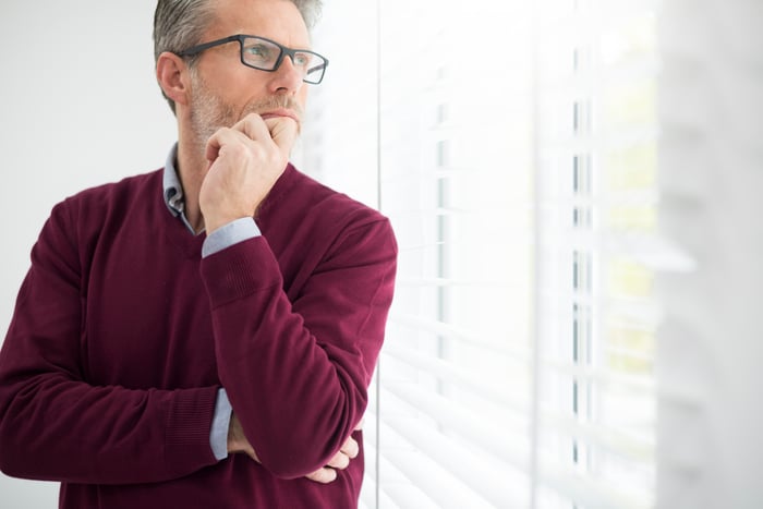 Businessman with hand on chin, deep in thought. 