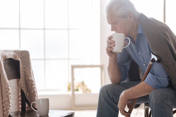 Elderly man desperately looking at an empty chair