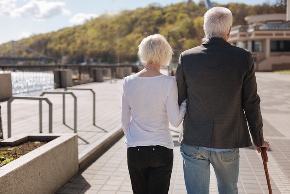Elderly couple walking along a river