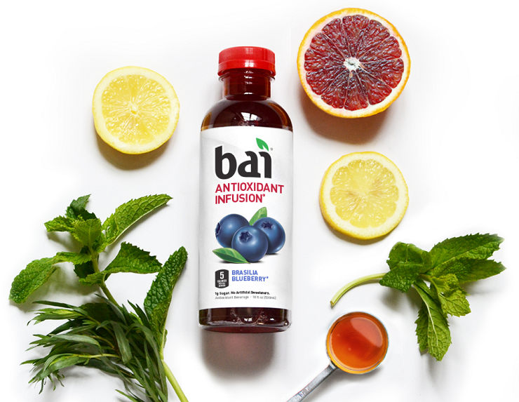 A bottle of Bai surrounded by fruits and herbs