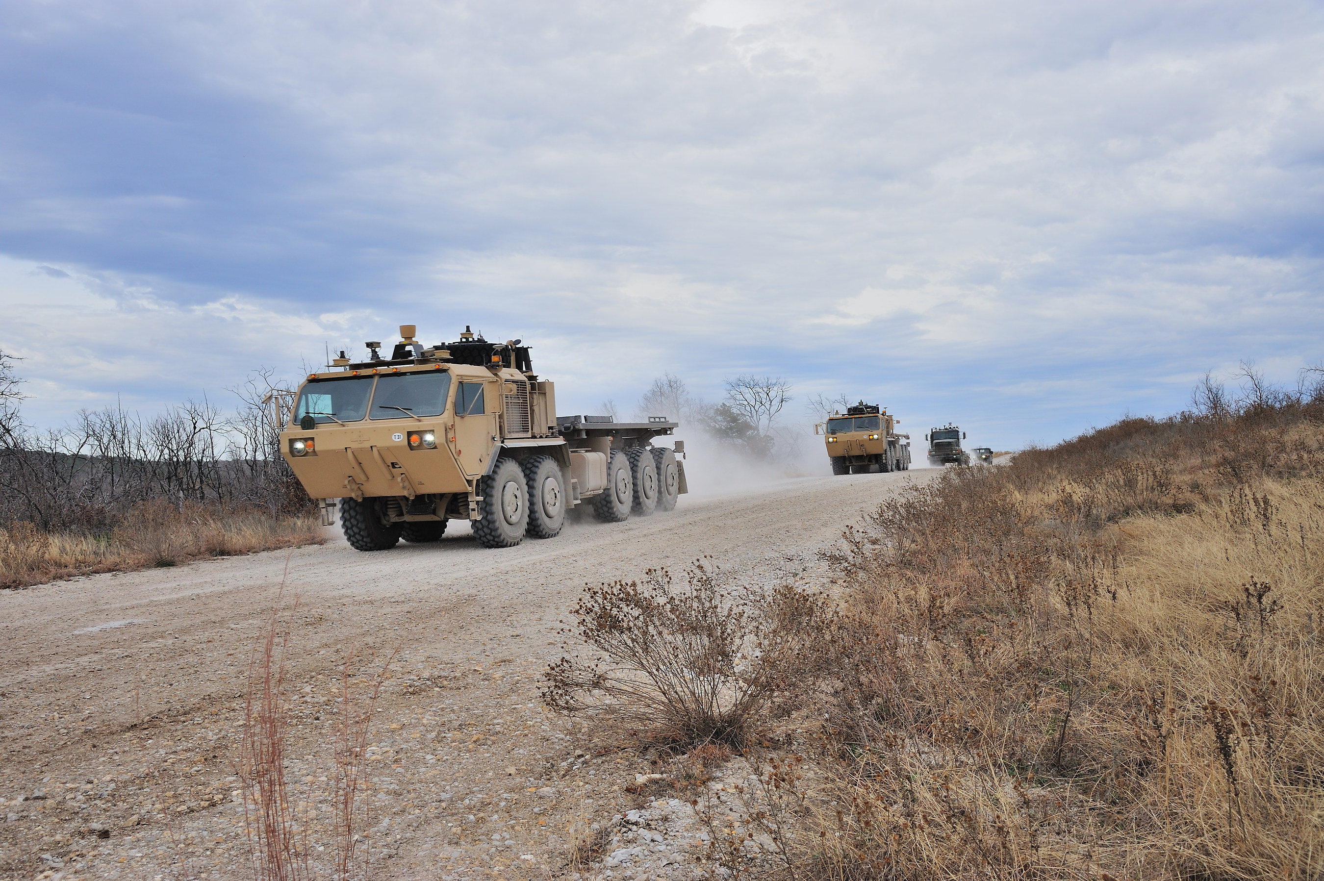 A autonomous driving military vehicle leading a convoy.