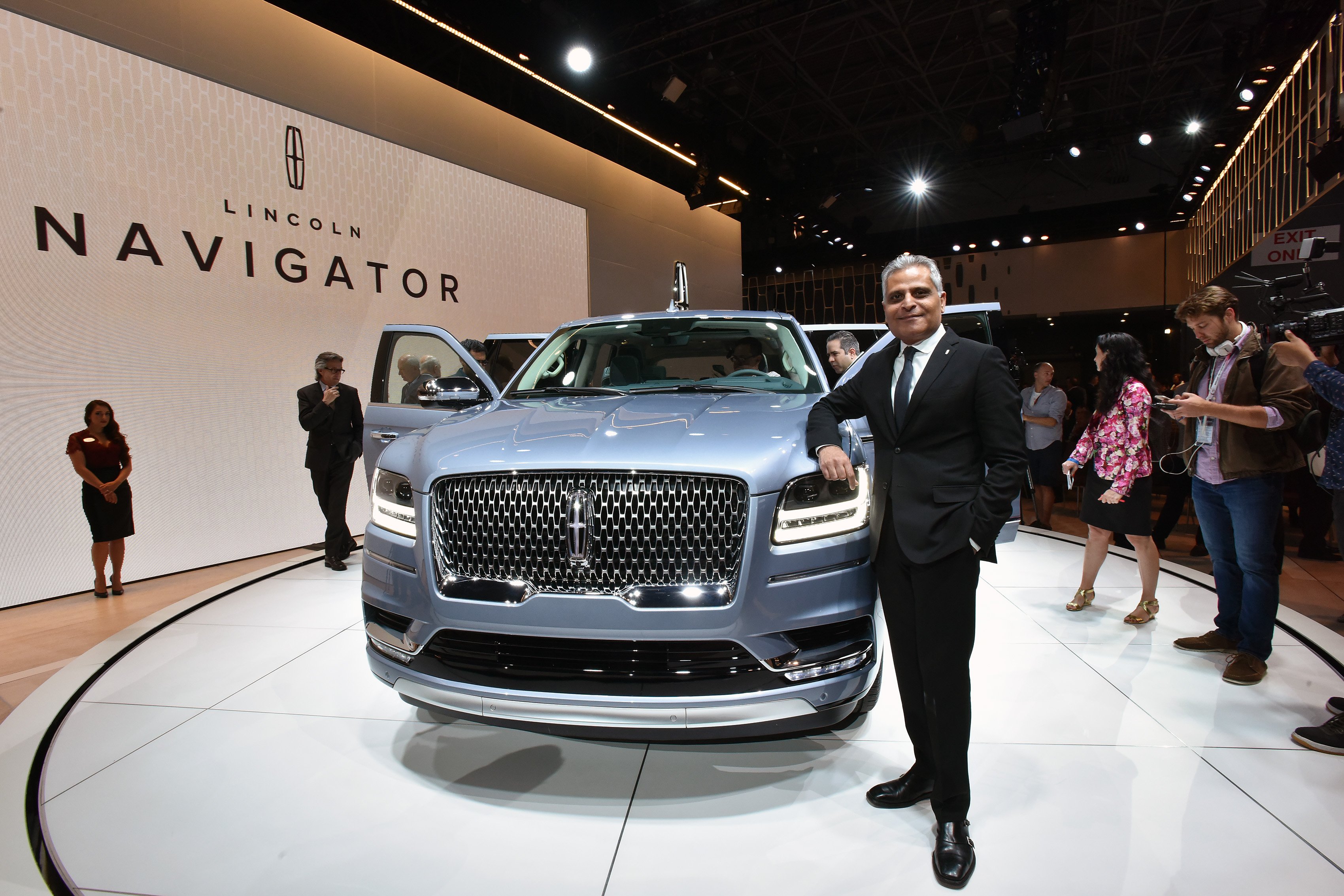 Galhotra is standing on Lincoln's auto-show stand with a Navigator SUV.