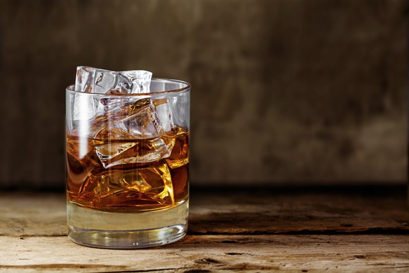 A glass of whiskey with ice.