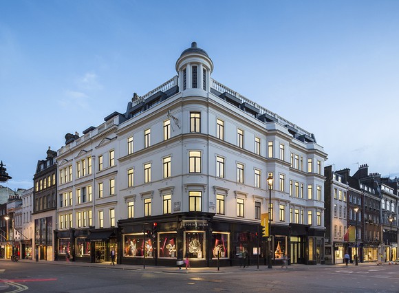 Wedge-shaped exterior building lit at twilight.