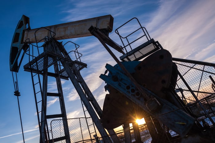 An oil pump with the sun shining through.