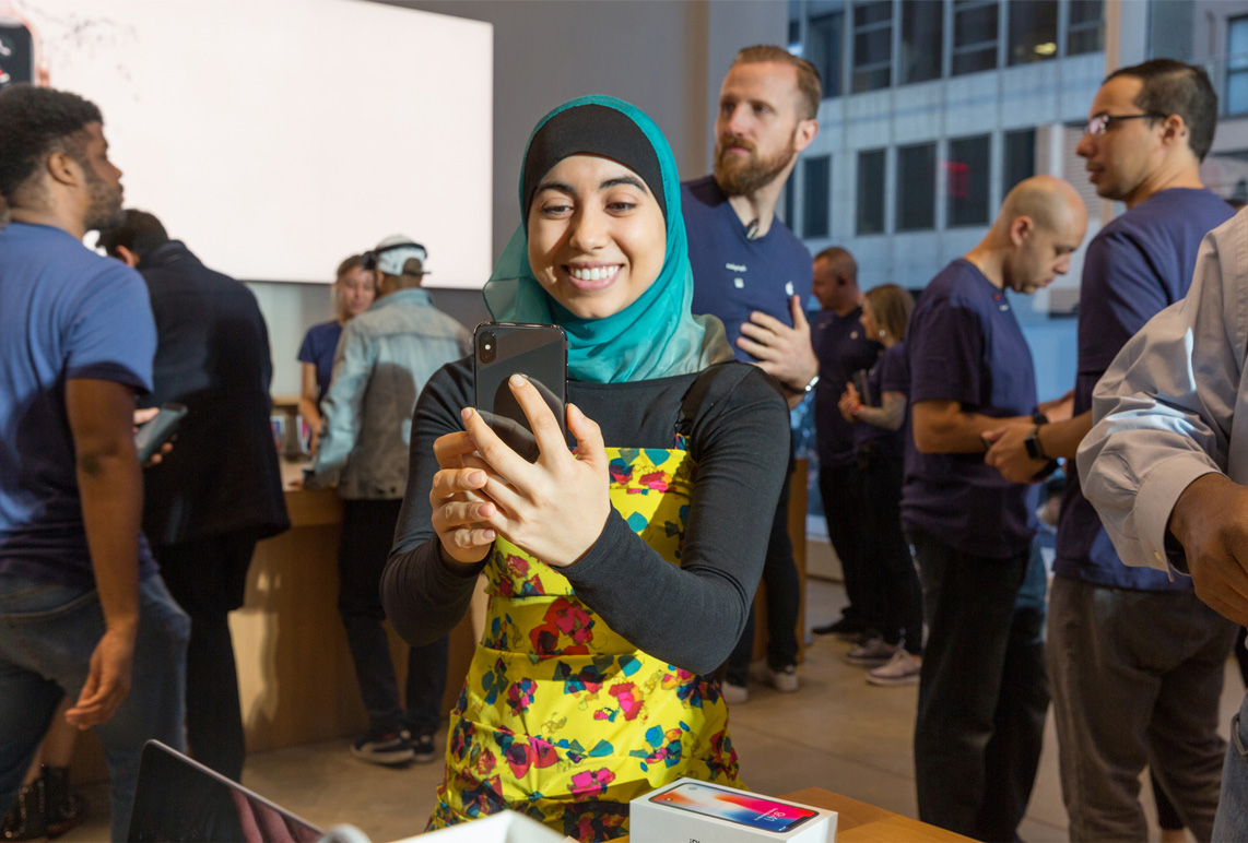 A customer holds the iPhone X in an Apple store
