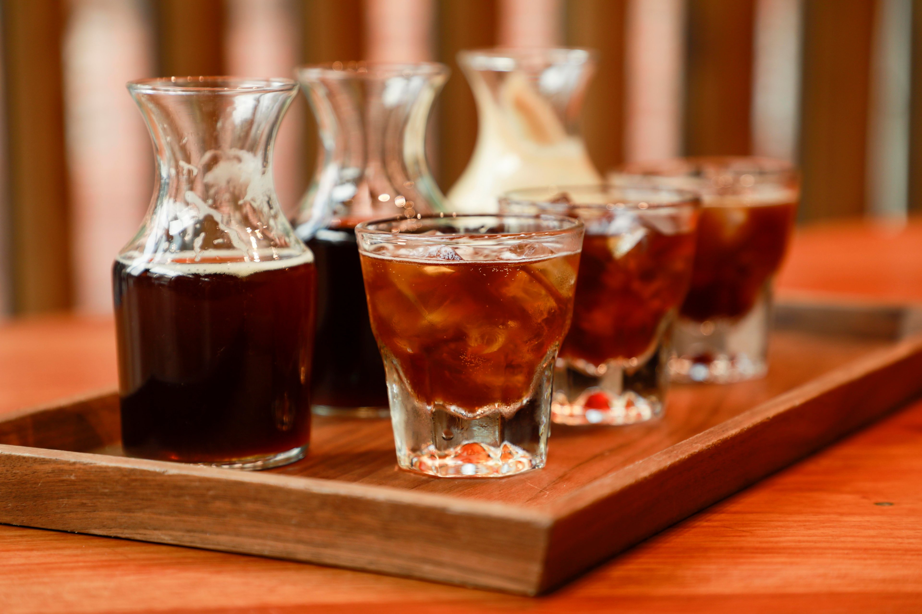 Starbucks cold-pressed espresso is shown in glass pitchers and cups