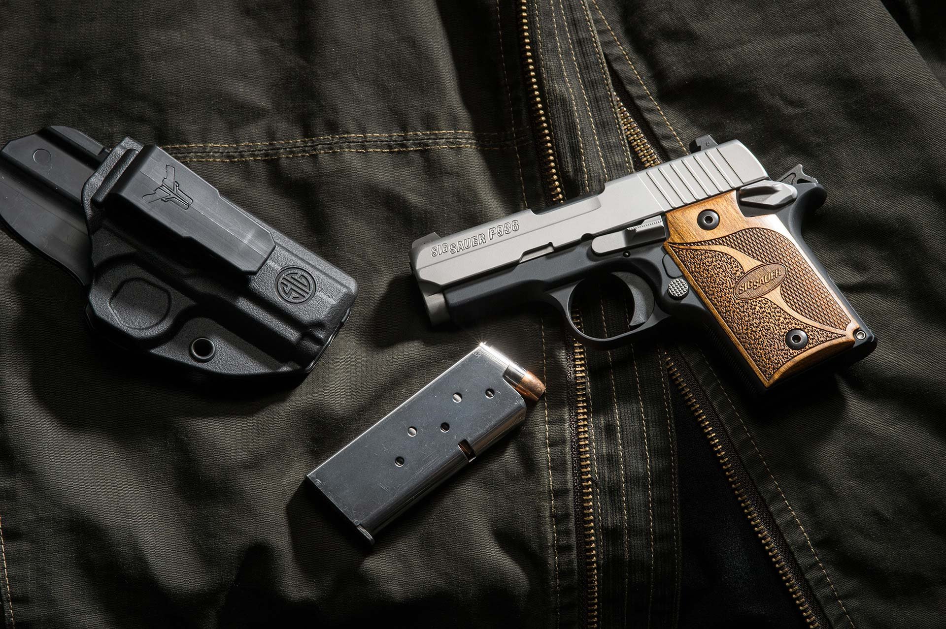 A Sig Sauer P938 and holster on top of a jacket.