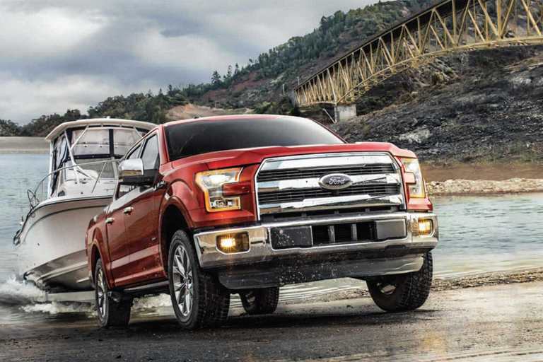 A Ford F-150 Lariat pulling a boat out of a lake.