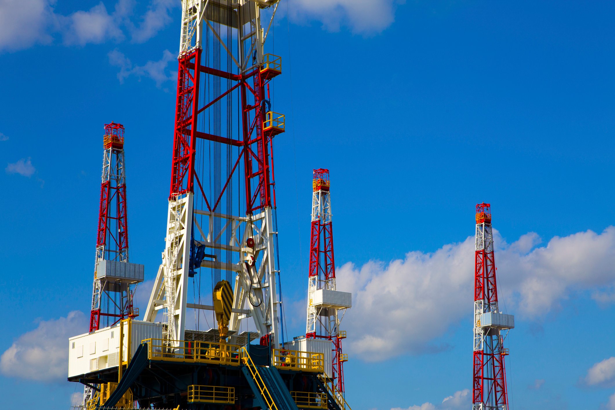 drilling rigs with a blue sky backdrop.