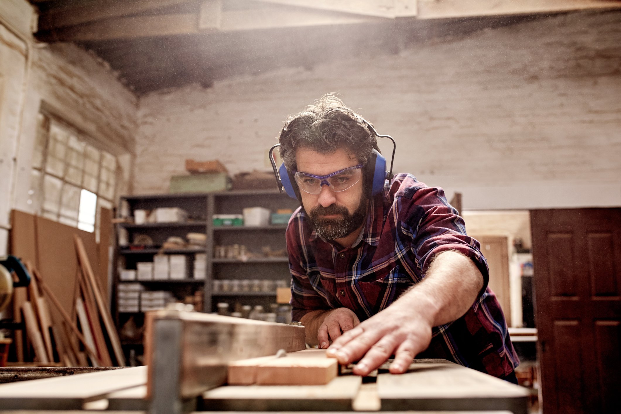 A carpenter cutting wood in his workshop