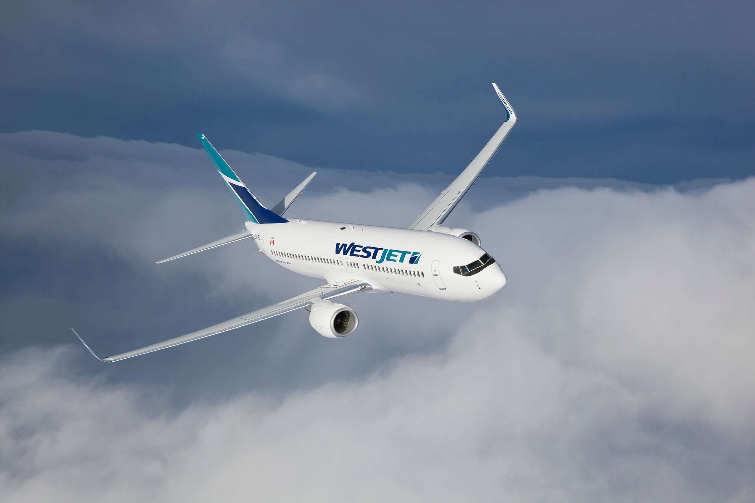 A WestJet plane flying over clouds