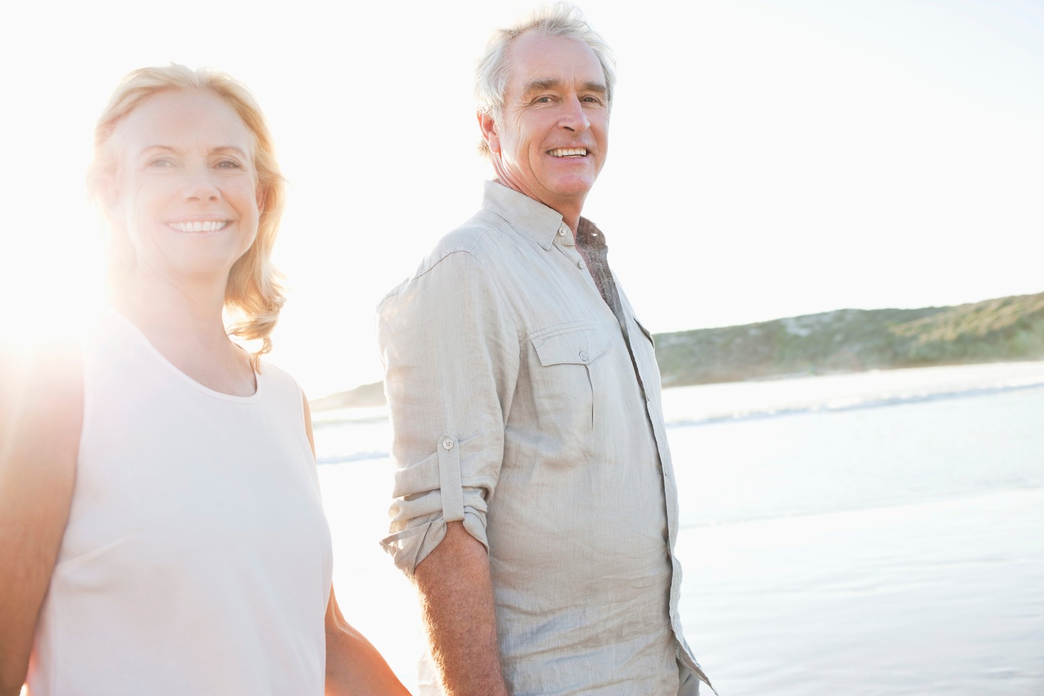 Senior couple smiling as they walk by the water