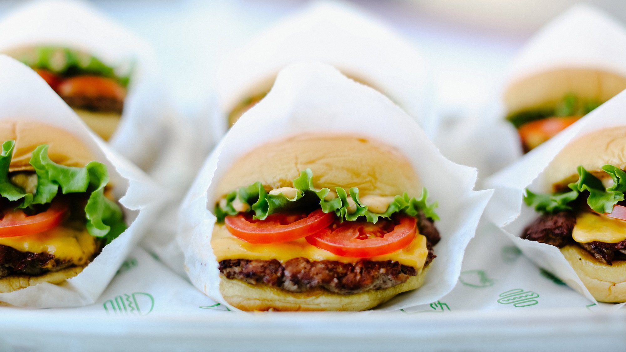Shake Shack burgers nearly arranged in paper wrapping