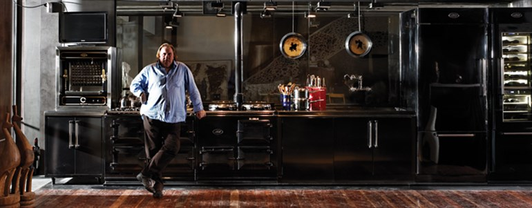 Acclaimed actor Gerard Depardieu standing in front of an AGA cooker.