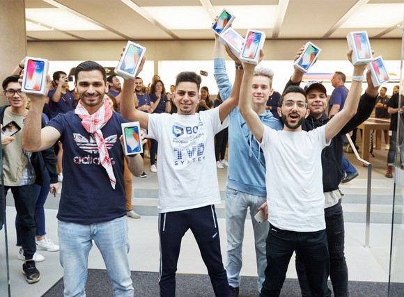 Customers holding new iPhone X devices on launch day