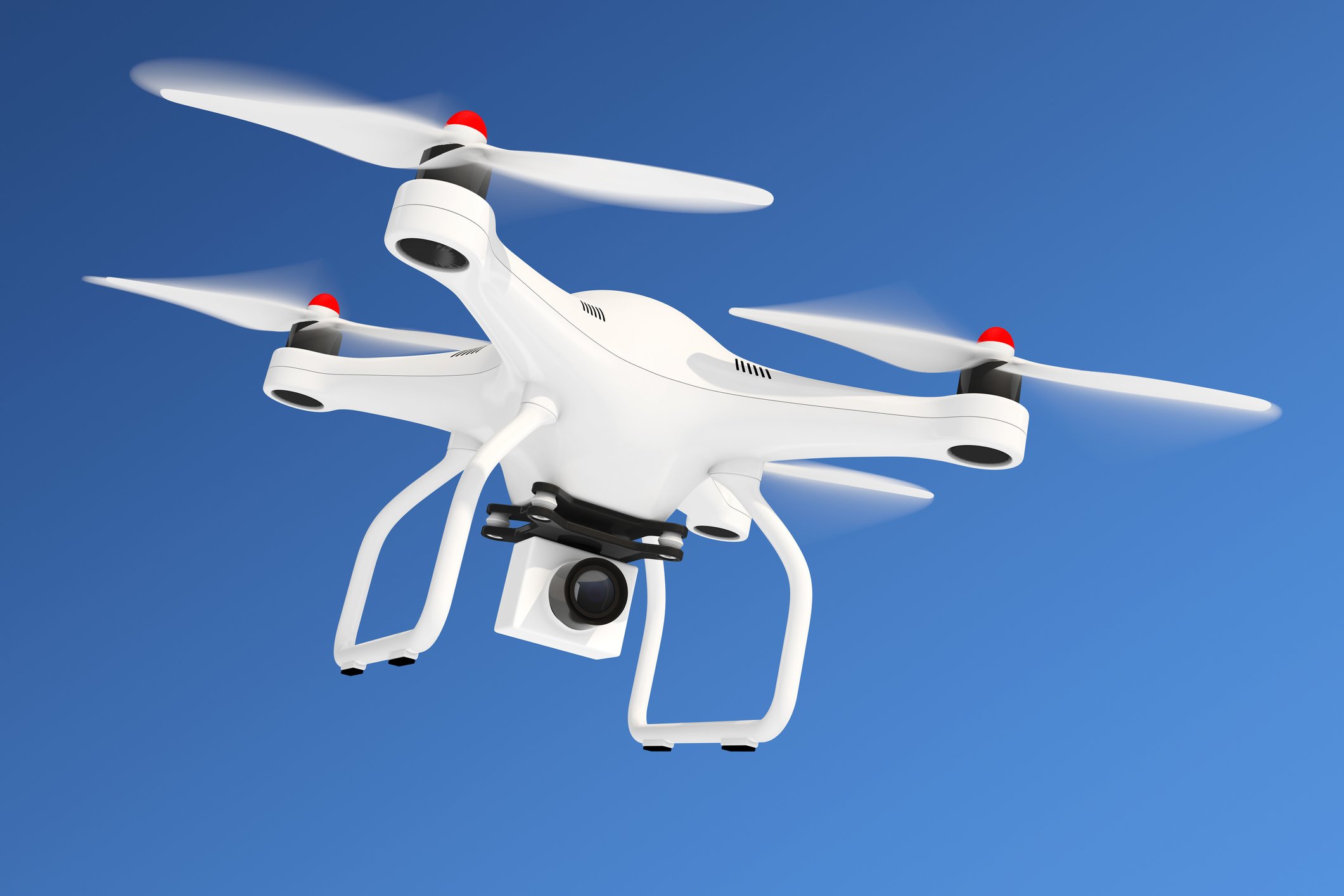 White drone equipped with camera flying in blue sky. 