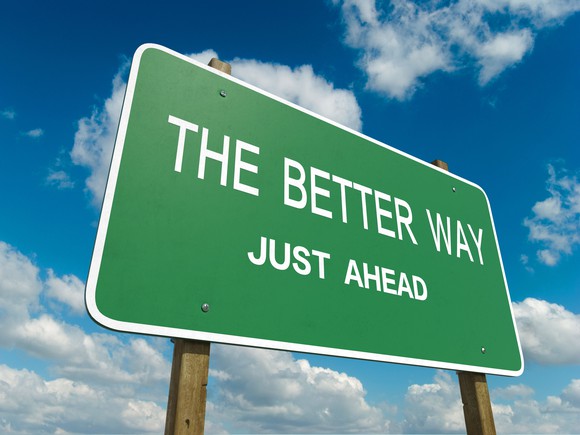 Highway sign in front of a partially blue sky reading: "The better way just ahead"