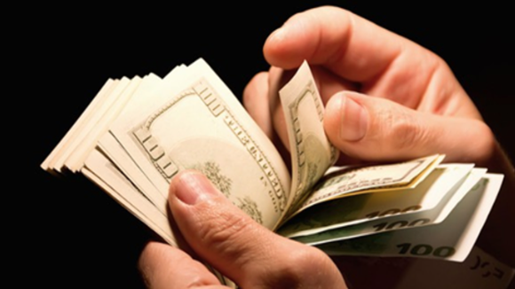 Hand holding $100 bills