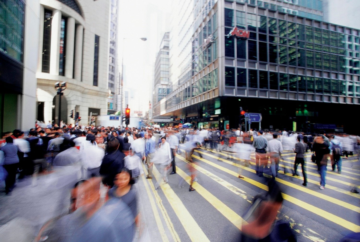 People walk down a busy street in a big city.