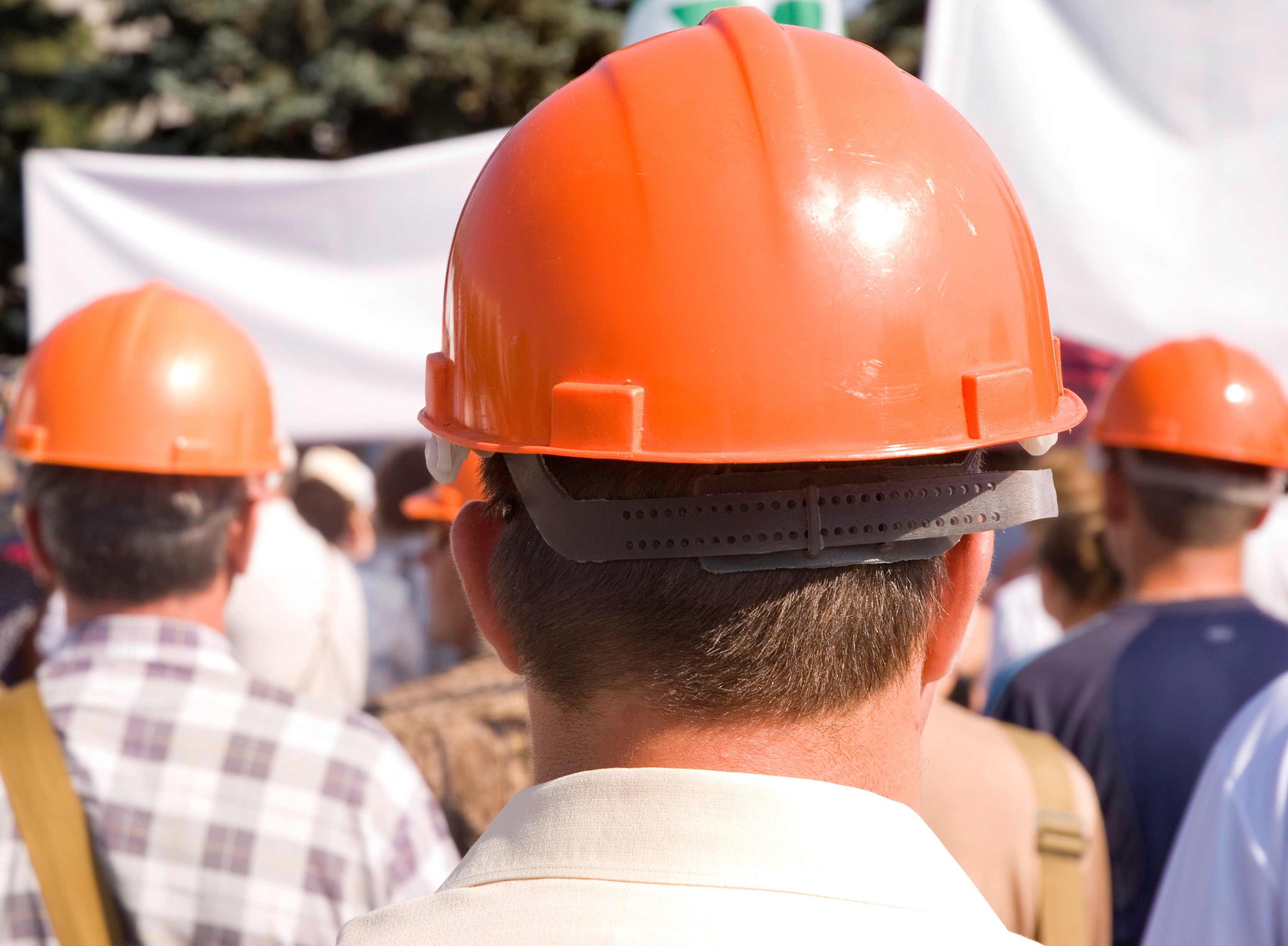 Men in hard hats appearing to be on strike.