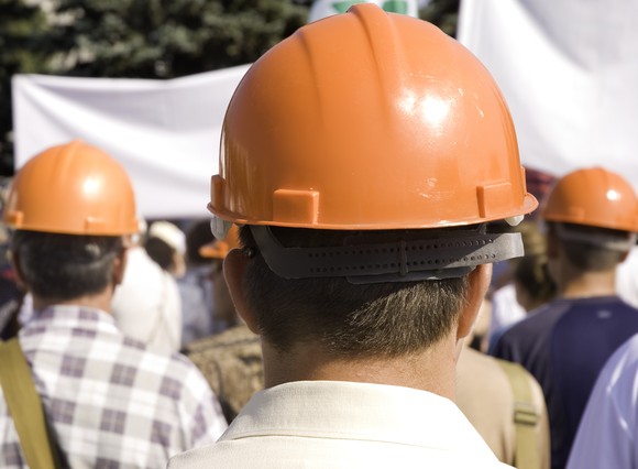 Men in hard hats appearing to be on strike.