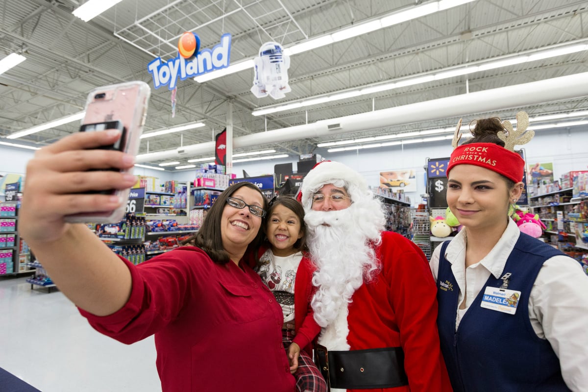 Wal-Mart employees take a selfie with Santa.
