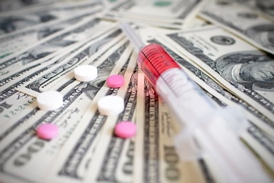 Pills and syringe on money