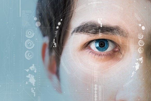 Close-up of a man's eye with technology icons around it.