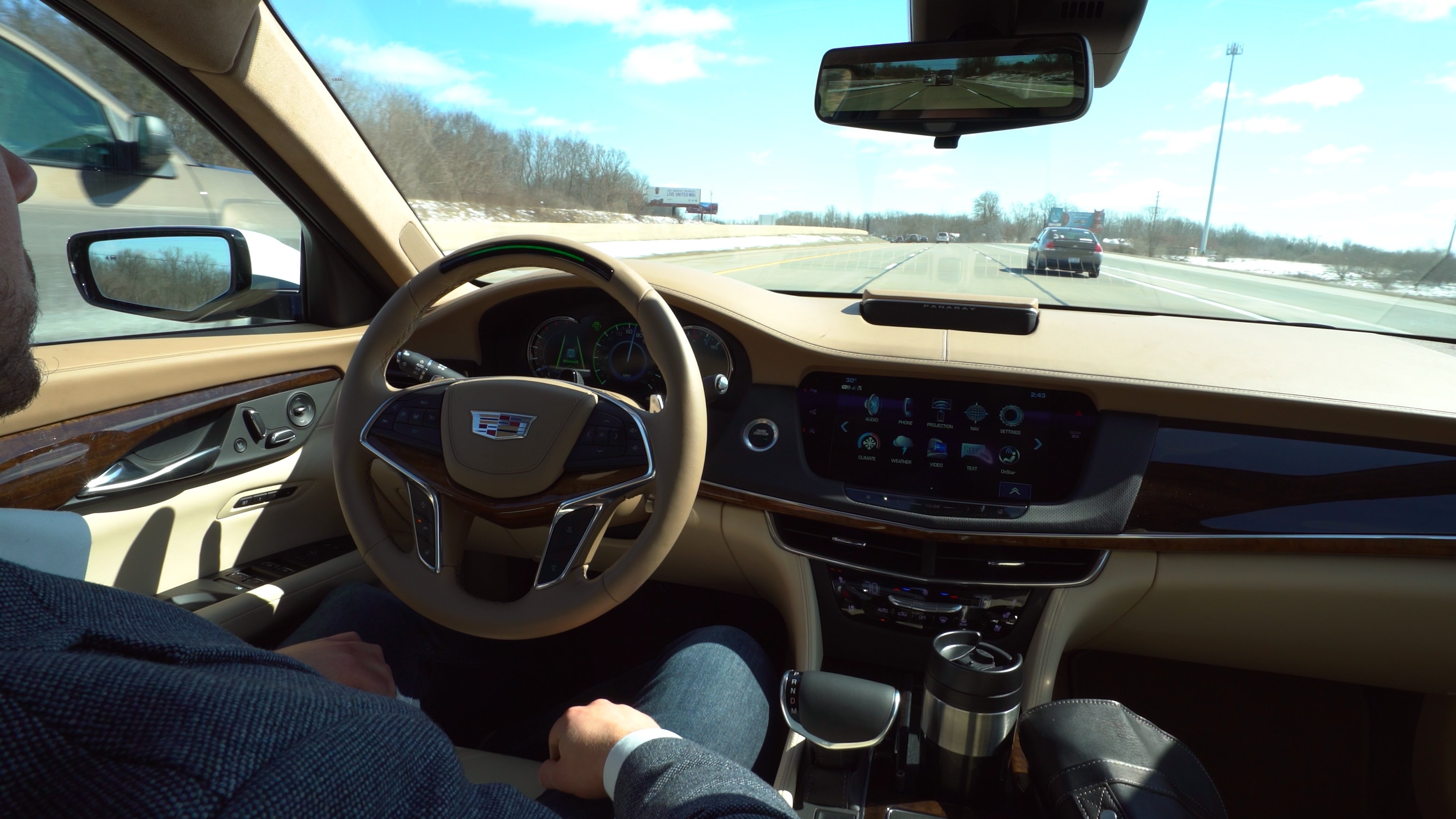 The steering wheel and dashboard of a Cadillac CT6 luxury sedan equipped with GM's Super Cruise highway driver-assist system. The driver's hands are off the steering wheel. 